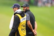 Dustin Johnson of the United States walks with his caddie Austin Johnson (Image via Getty)